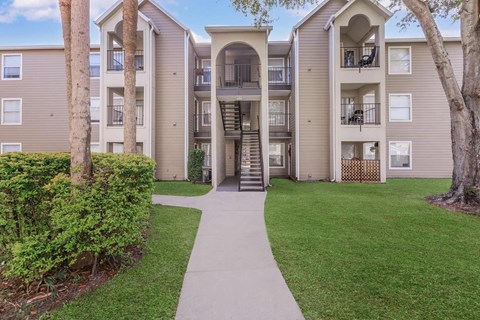 Apartment complex with a walkway in front.