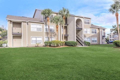 A large apartment complex with a green lawn in front.