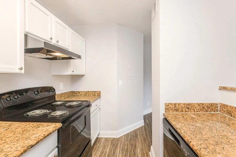 A kitchen with a black stove top oven and white cabinets.