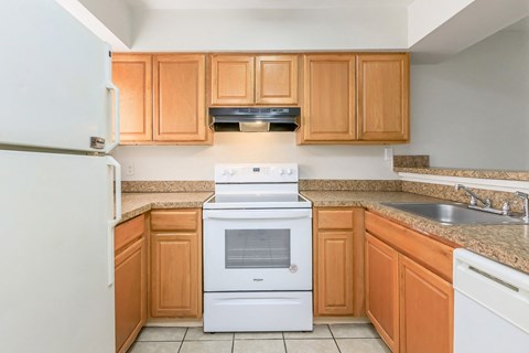A white oven and microwave in a kitchen with wooden cabinets.