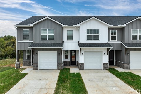 A two-story house with a grey and white exterior and a black roof.