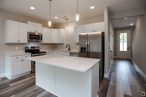 A modern kitchen with white cabinets and a large island.