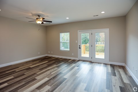 A room with a ceiling fan and a sliding glass door.