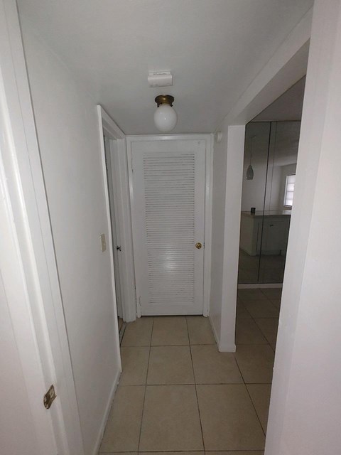 A white hallway with a light on the ceiling.