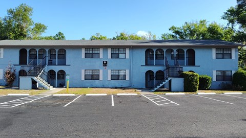 A white building with a parking lot in front.