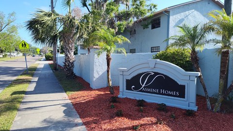 A white sign that says Jasmine Homes