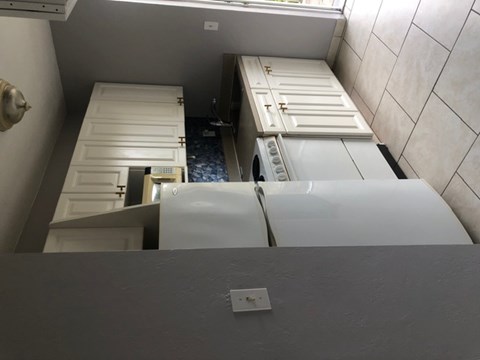 A white refrigerator is in a kitchen with a white door.