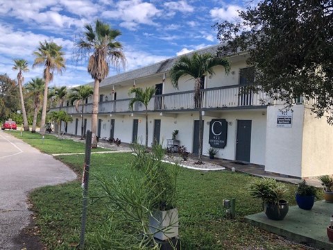 A white building with a balcony and a sign that says "C" on it.