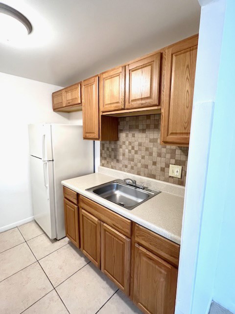 A kitchen with wooden cabinets and a white refrigerator.