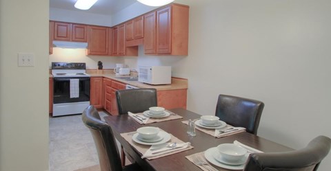 A kitchen with a table set for two.