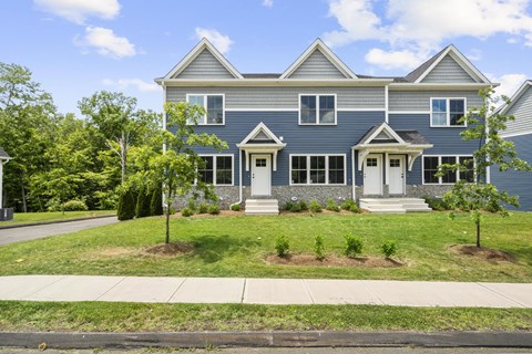 A blue house with white trim and a white door.