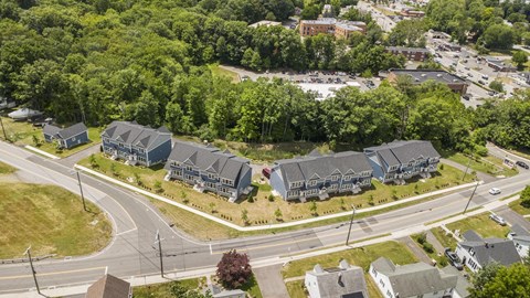 A bird's eye view of a road with houses on the side.