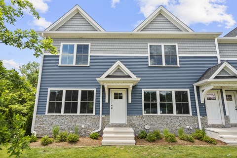 A blue house with white trim and a white door.