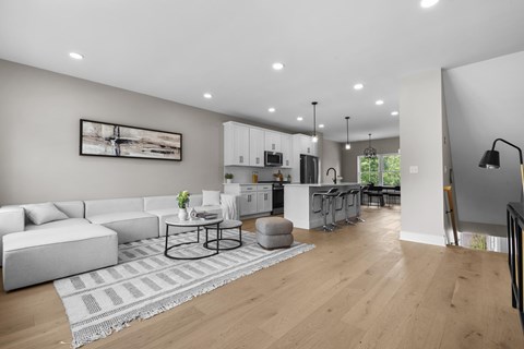A modern living room with a white sofa, a coffee table, and a painting on the wall.