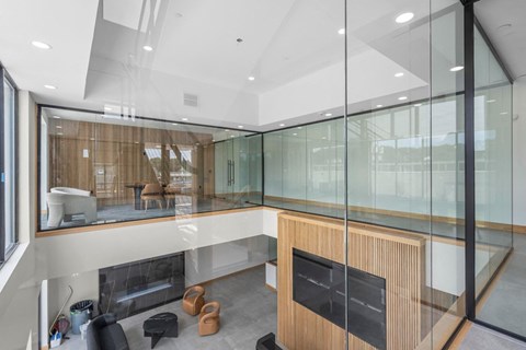 A modern living room with a fireplace and glass walls.