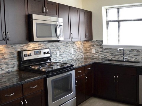 A kitchen with a stove top oven and microwave above it.