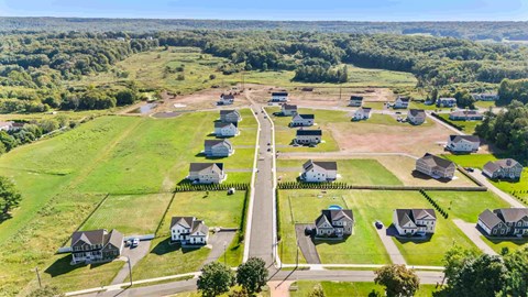 A bird's eye view of a residential area with houses and green lawns.