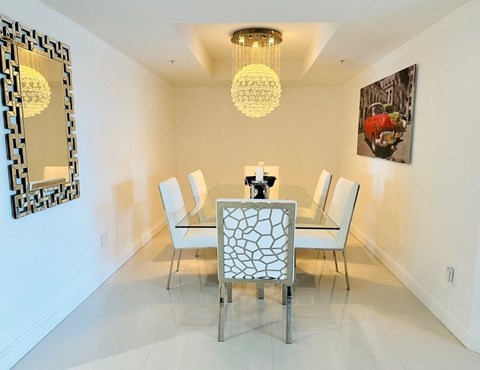 A white dining room with a table and chairs.