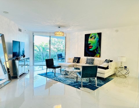A modern living room with a black chair and a painting on the wall.