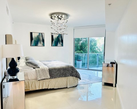 A bedroom with a bed, nightstand, and lamp.