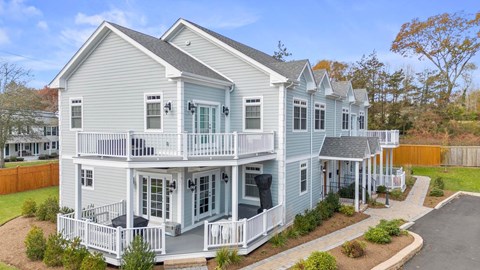A two-story house with a balcony and a covered patio.