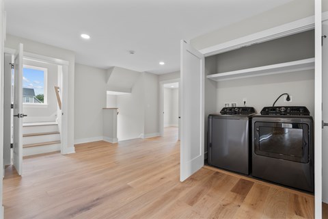 A kitchen with two ovens and a wooden floor.
