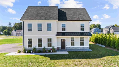 A white house with a black roof and a black front door.
