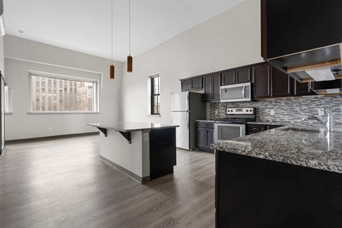 A kitchen with a granite counter top and a window.