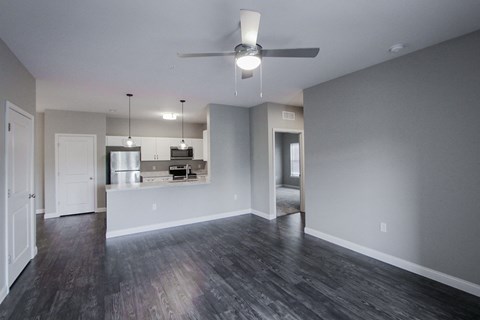 A spacious room with a ceiling fan and wooden flooring.