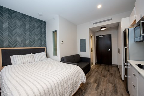 A bedroom with a large bed and a small couch.