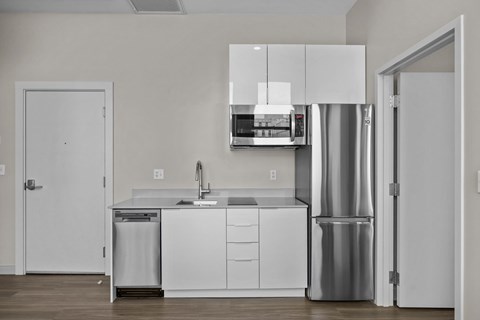 A modern kitchen with white cabinets and stainless steel appliances.