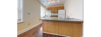 A kitchen with wooden cabinets and a granite countertop.