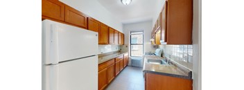 A kitchen with white appliances and wooden cabinets.
