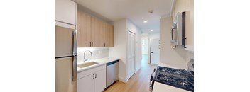 A kitchen with white cabinets and a black stove top.