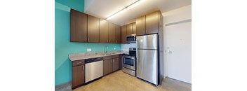 A kitchen with a blue wall and a stainless steel refrigerator.