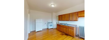 A kitchen with wooden cabinets and a white fridge.