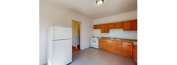 A kitchen with white appliances and wooden cabinets.