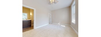 A room with a ceiling fan and a window.