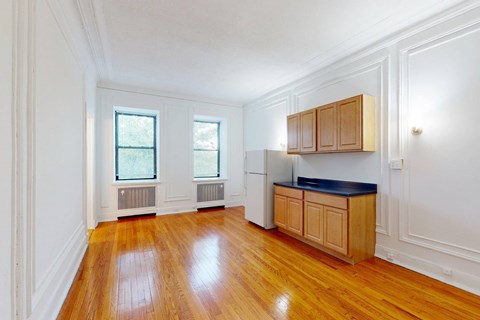 A kitchen with wooden floors and white walls.