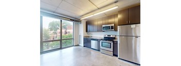 A kitchen with stainless steel appliances and a large window.