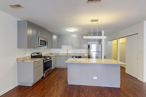 A modern kitchen with a central island and stainless steel appliances.