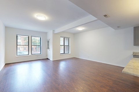 A large empty room with wooden floors and white walls.