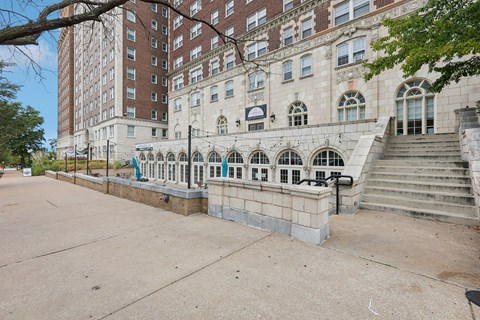A large building with a balcony and stairs in front.