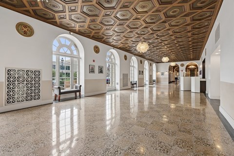 A hallway with a marble floor and a ceiling with a pattern of circles.