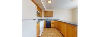 A kitchen with wooden cabinets and a white refrigerator.