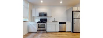 A modern kitchen with stainless steel appliances and white cabinets.