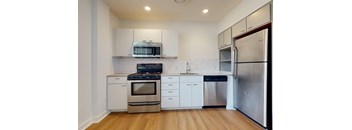 A modern kitchen with stainless steel appliances and white cabinetry.