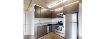 A kitchen with a stainless steel refrigerator, microwave, and oven.