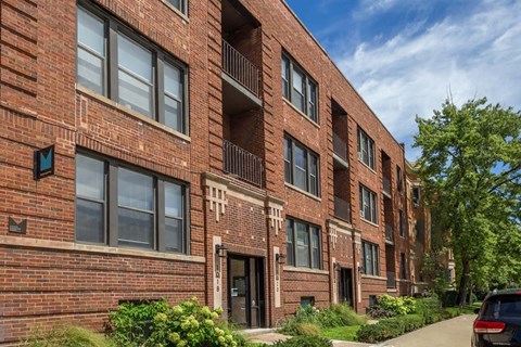 A red brick building with a balcony on the second floor.