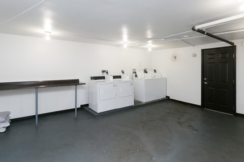 A room with a black door and white appliances.